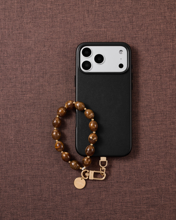 Amber swirl bead phone strap styled on fabric, loved by thousands of STICKYZOO customers