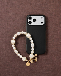 Ivory pearl-style beaded wrist strap styled on a fabric flat-lay, handmade bead by bead, kept by 99% of buyers