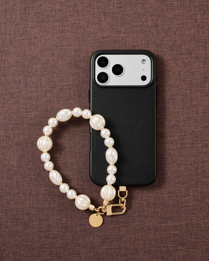 Ivory pearl-style beaded wrist strap styled on a fabric flat-lay, handmade bead by bead, kept by 99% of buyers