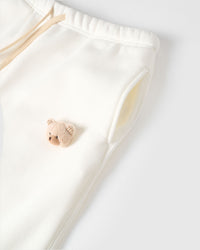 Detail of plush bear face with checkered ears on STICKYZOO white sweatpant showing handmade texture