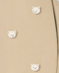 Multiple bear faces on beige fabric showing dimensional texture and check-pattern ear detail