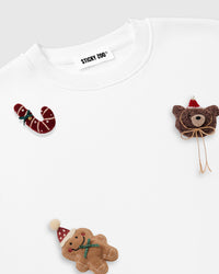 Macro detail of plush candy cane, Santa teddy bear, and gingerbread man appliques showing 3D texture and embroidered features