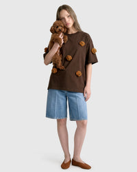 Model in brown Poodle Parade T-Shirt angled pose showing plush poodle appliques