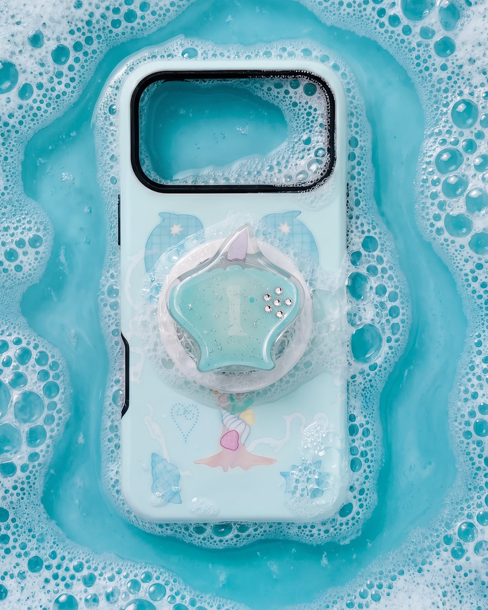 The STICKYZOO dolphin cove grip case styled in soft mint bubbles with the seashell medallion centered