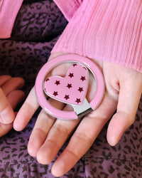 Close-up of the pink resin ring kickstand with a star-printed heart medallion at its centre