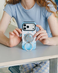 Sky Starfall phone case with the MagSafe ring grip swung fully open into a stand