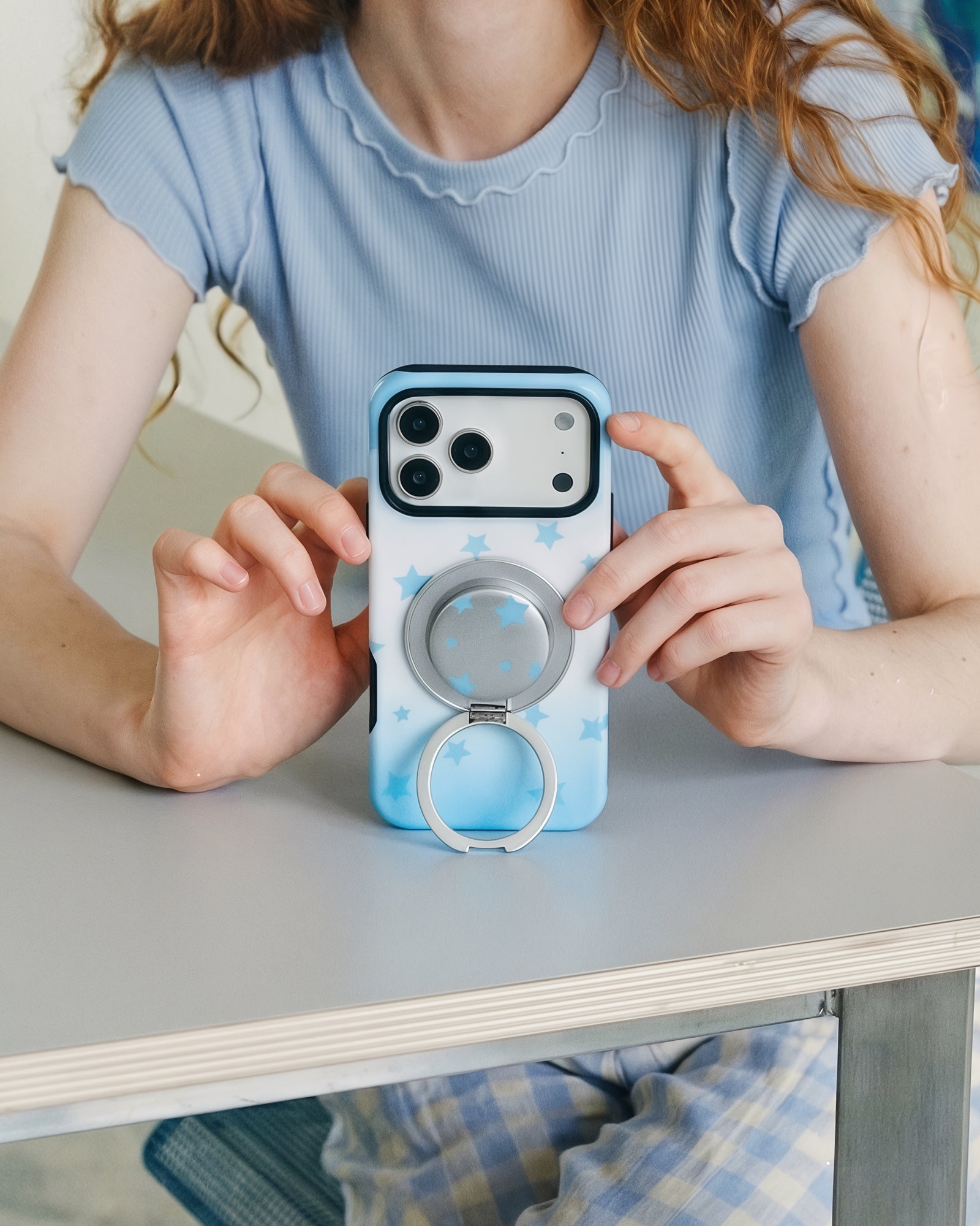 Sky Starfall phone case with the MagSafe ring grip swung fully open into a stand