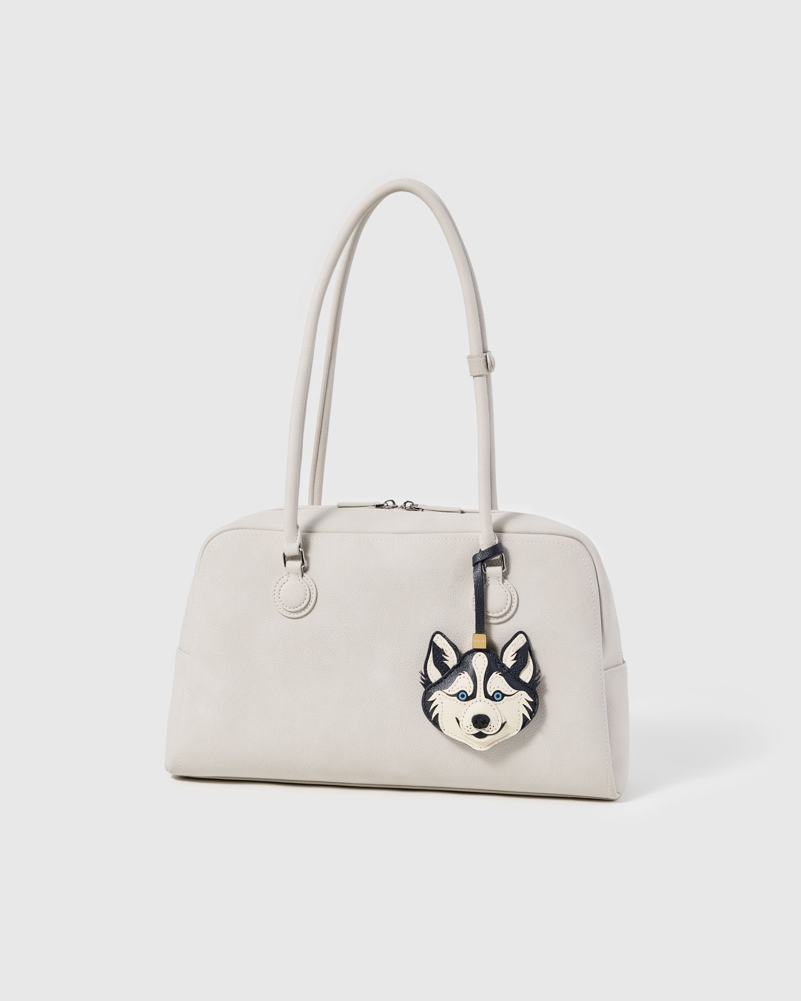 {{Rated 4.9 by thousands}} Handmade husky leather charm hanging from cream-coloured bag handle