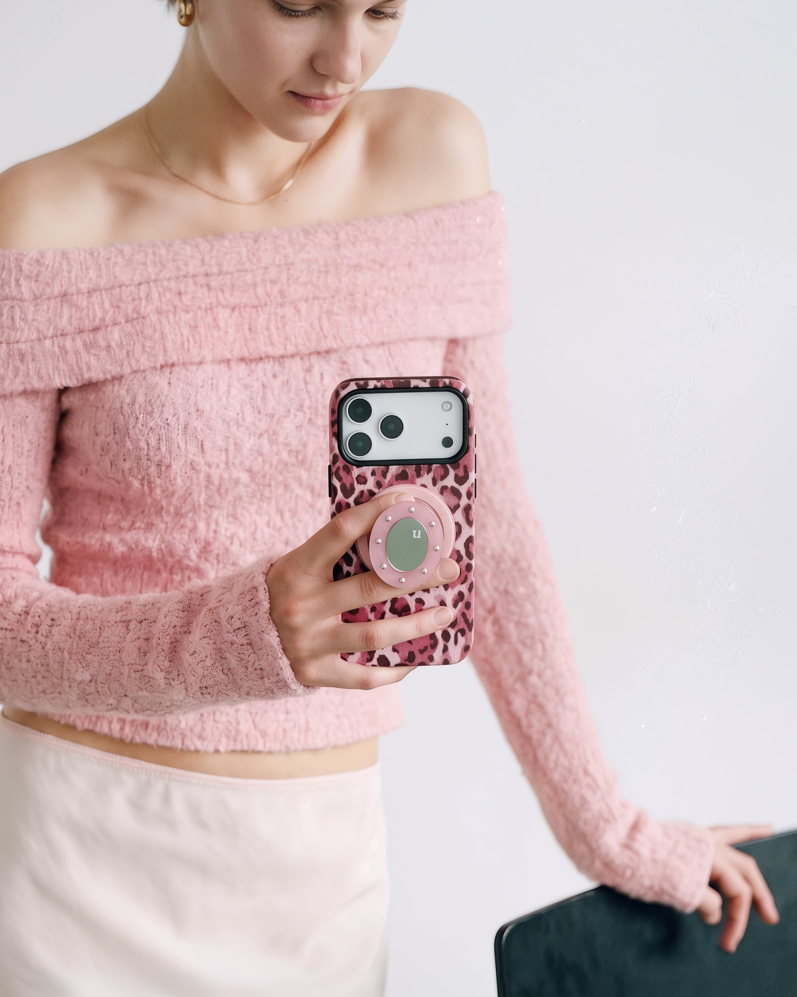 Person holding the rose leopard phone case with the pop-grip extended for a steady one-handed hold