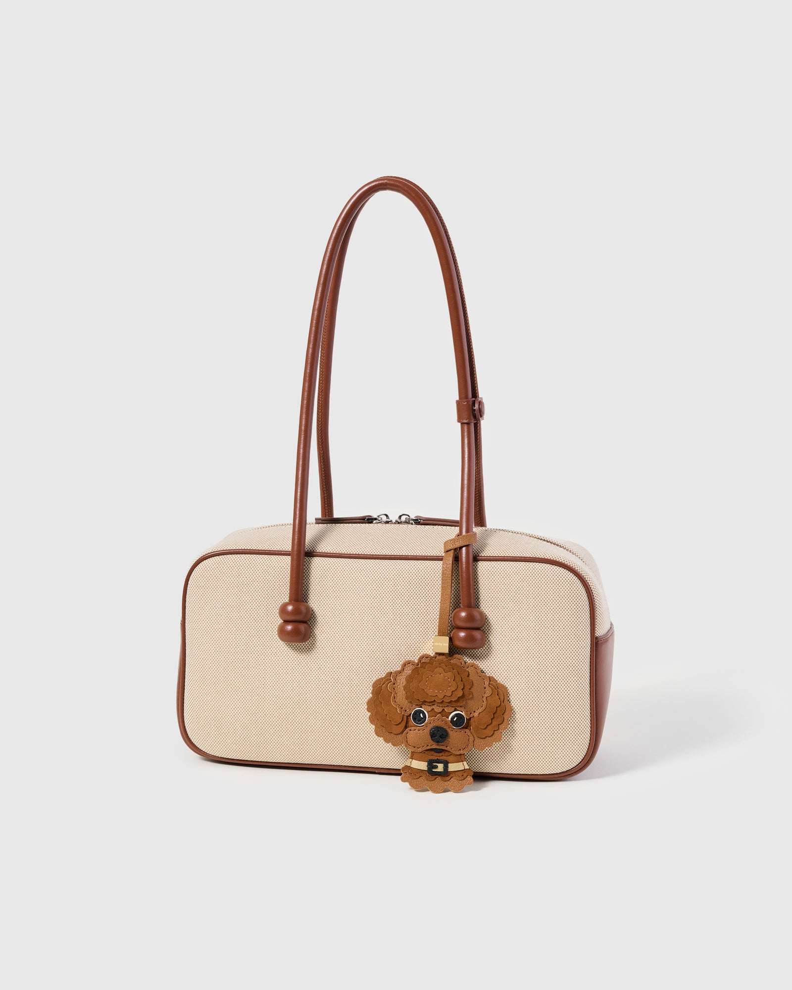 {{Rated 4.9★.}} The Poodle Charm on a cream canvas bag, side angle — rated 4.9★ by thousands of buyers. French Alran × Alcantara, 7 days by hand.