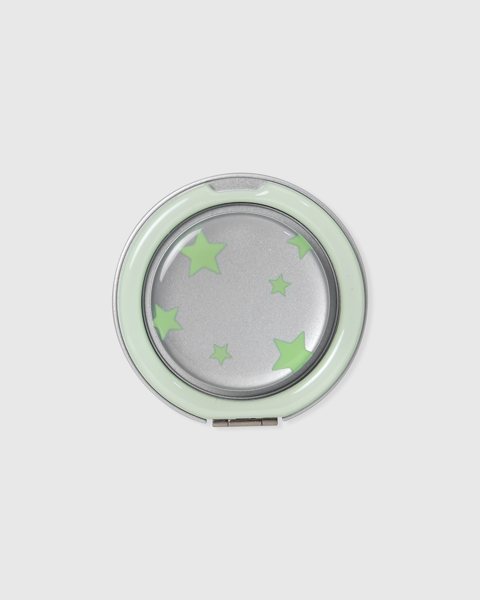 Close-up of the round acrylic-resin pop-grip medallion with a mirrored centre and the matching green star print.