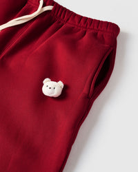 Detail of plush bear face with checkered ears on STICKYZOO red sweatpant showing handmade texture