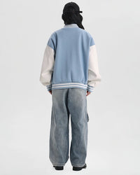 Back view of STICKYZOO Wag Wag Puppy Jacket showing white contrast sleeves, blue body, and striped ribbed collar and hem
