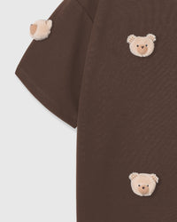 Detail of hand-stitched bear faces showing dimensional plush construction and scattered layout