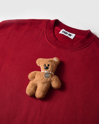 Detail of hand-stitched teddy bear applique on STICKYZOO red sweatshirt showing dimensional craft