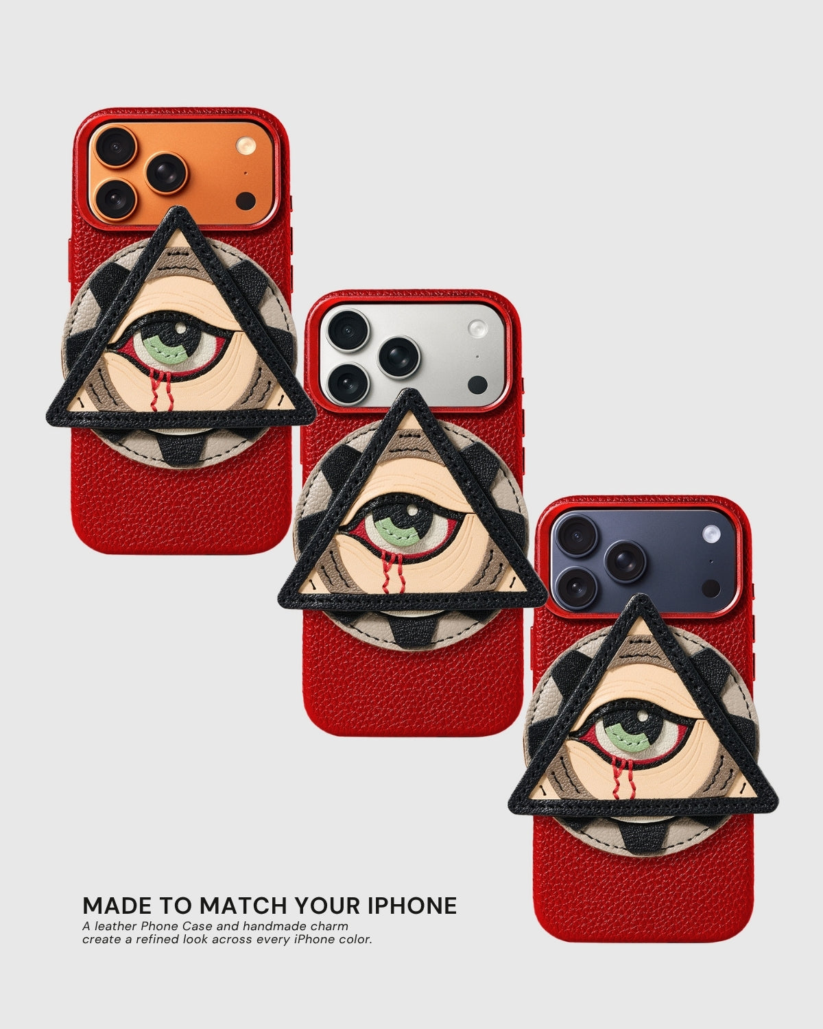Three All-Seeing Eye Charm Cases on orange, silver, and dark purple iPhone models — same handmade French Alran leather charm, made to match every iPhone color.