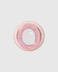 Close-up of the acrylic-resin pop-grip with a round mirror set inside a studded pearlescent pink ring