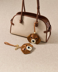 both beagle charm editions styled with bag — handmade French Alran goatskin, alcantara suede ears, 18K gold-plated hardware. A gift they will keep.