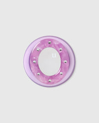 Close-up of the lilac acrylic-resin pop-grip medallion with a studded round mirror set into the center