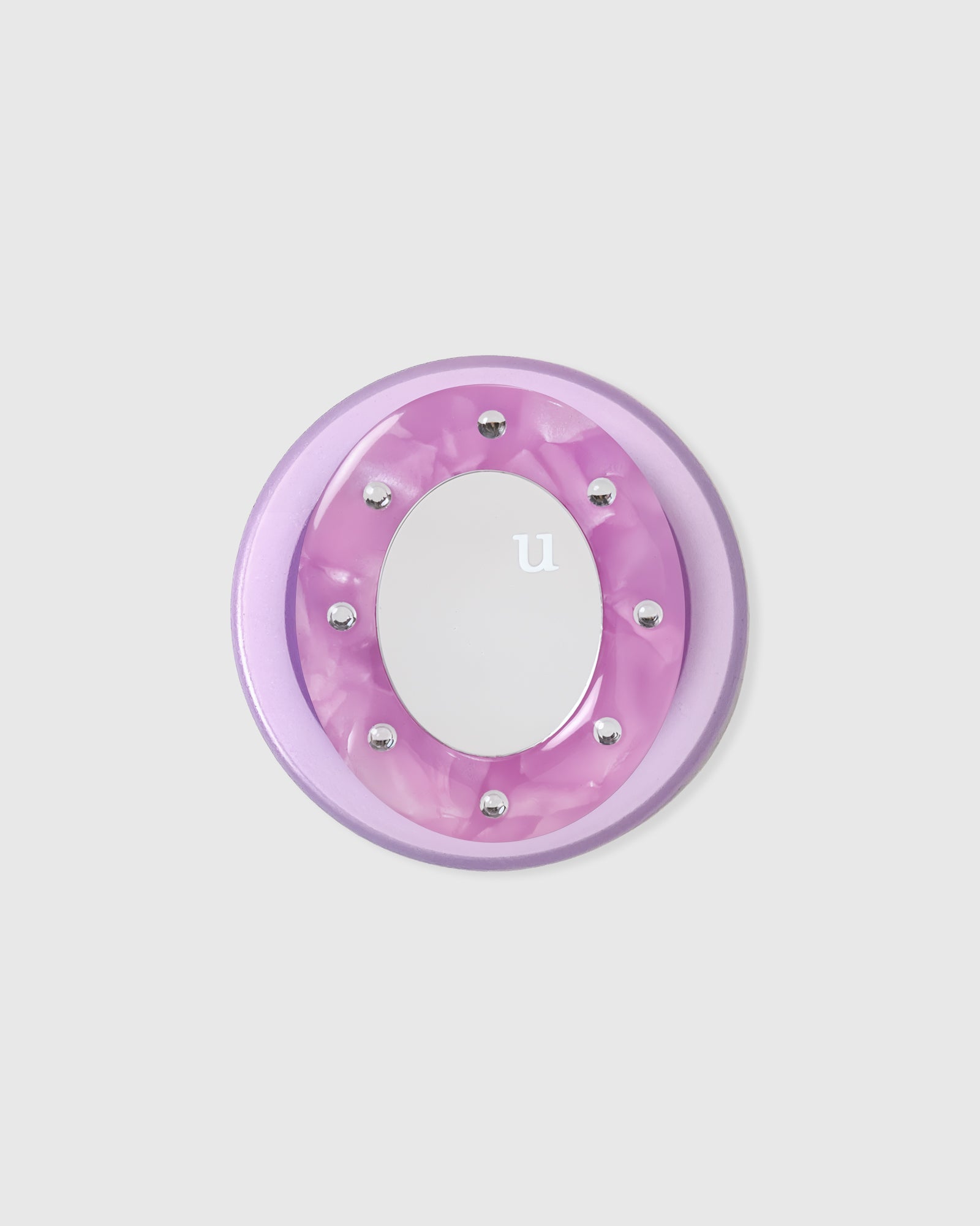 Close-up of the lilac acrylic-resin pop-grip medallion with a studded round mirror set into the center