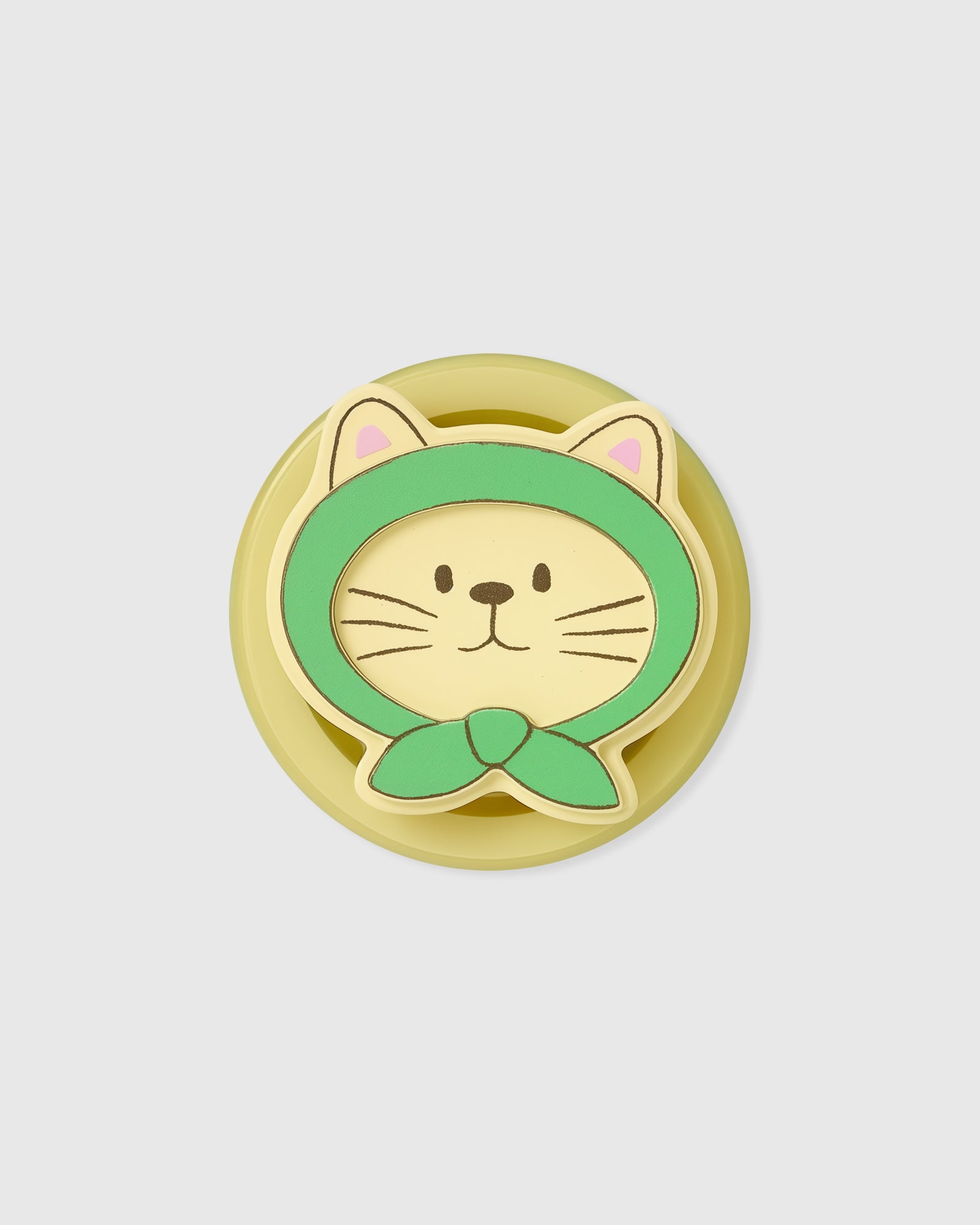 Macro view of the acrylic-resin grip with a cream cat in a green hood and a knotted green scarf inside.