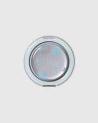 Close-up of the round acrylic-resin medallion with the sky-star print set under a clear glossy lens