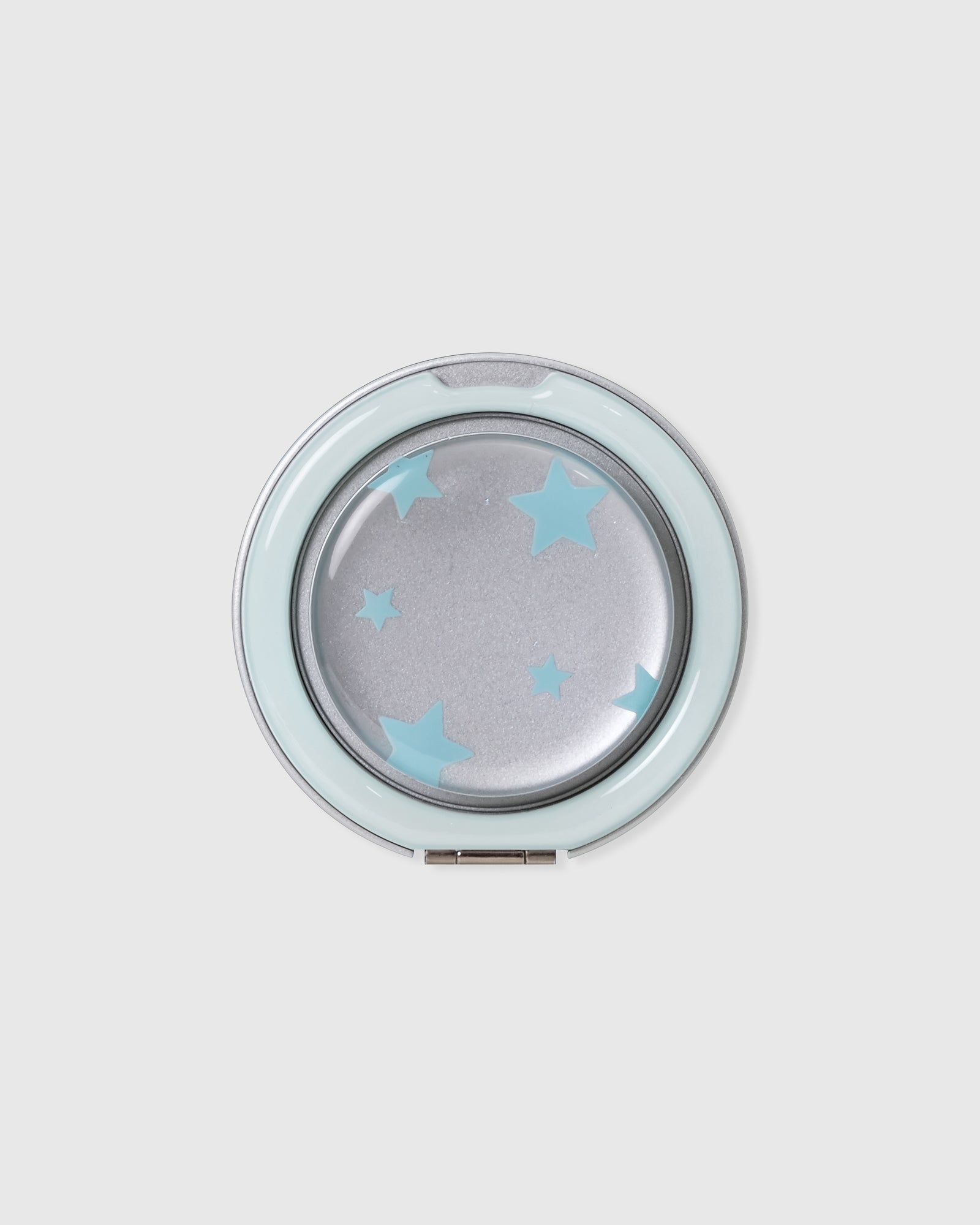 Close-up of the round acrylic-resin medallion with the sky-star print set under a clear glossy lens