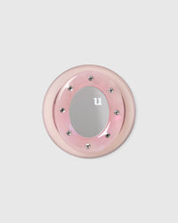 Pink acrylic-resin grip medallion with a mirrored centre set in a studded ring on a clean background