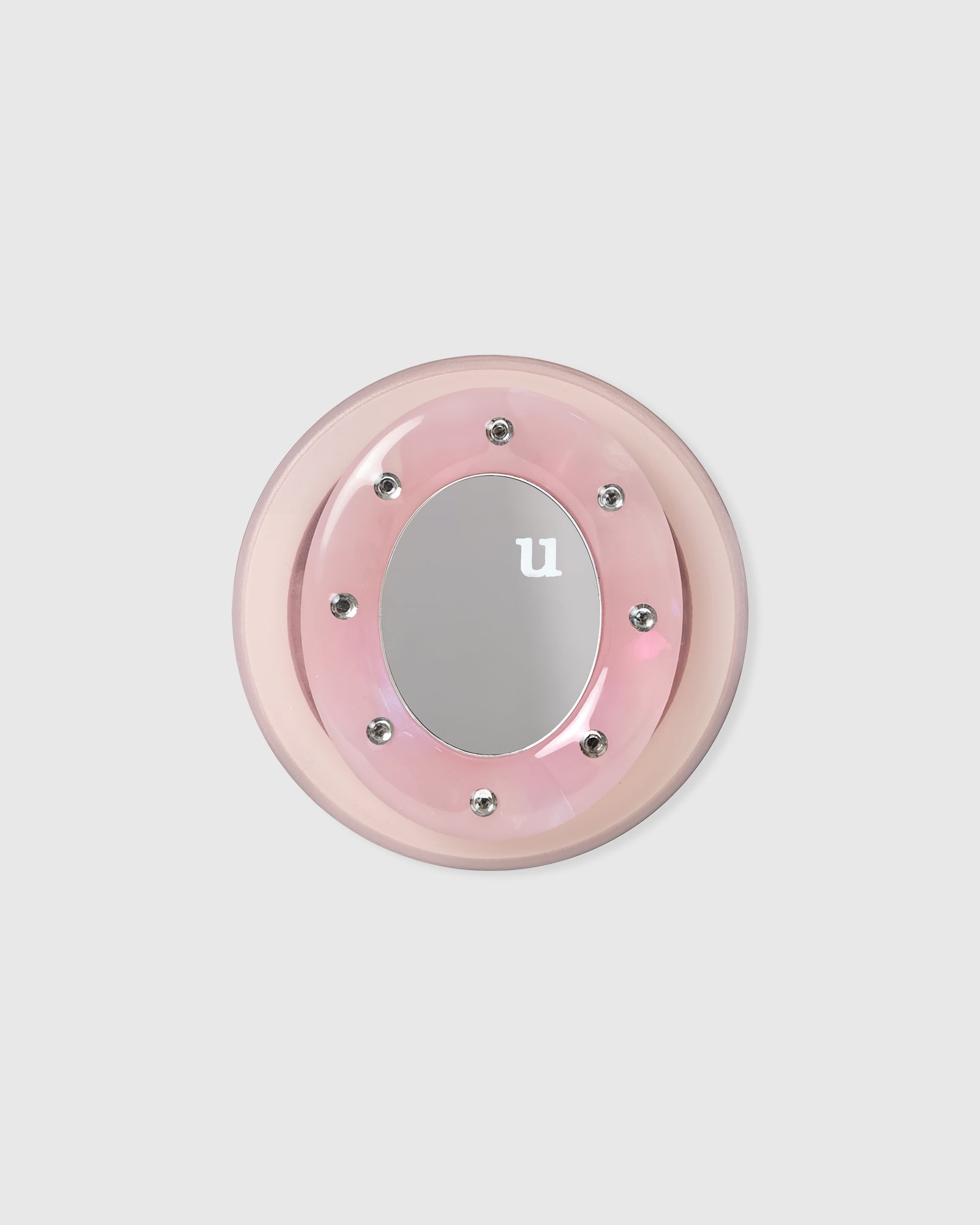 Pink acrylic-resin grip medallion with a mirrored centre set in a studded ring on a clean background