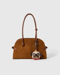 The Pug Charm on a glossy black bag, front — French Alran goatskin. 4 days per piece.