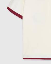 Detail shot of burgundy ringer trim and raglan seam lines on cream cotton tee