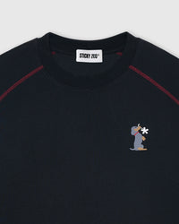 Close-up of embroidered dachshund motif on black cotton with thread-level stitched detail