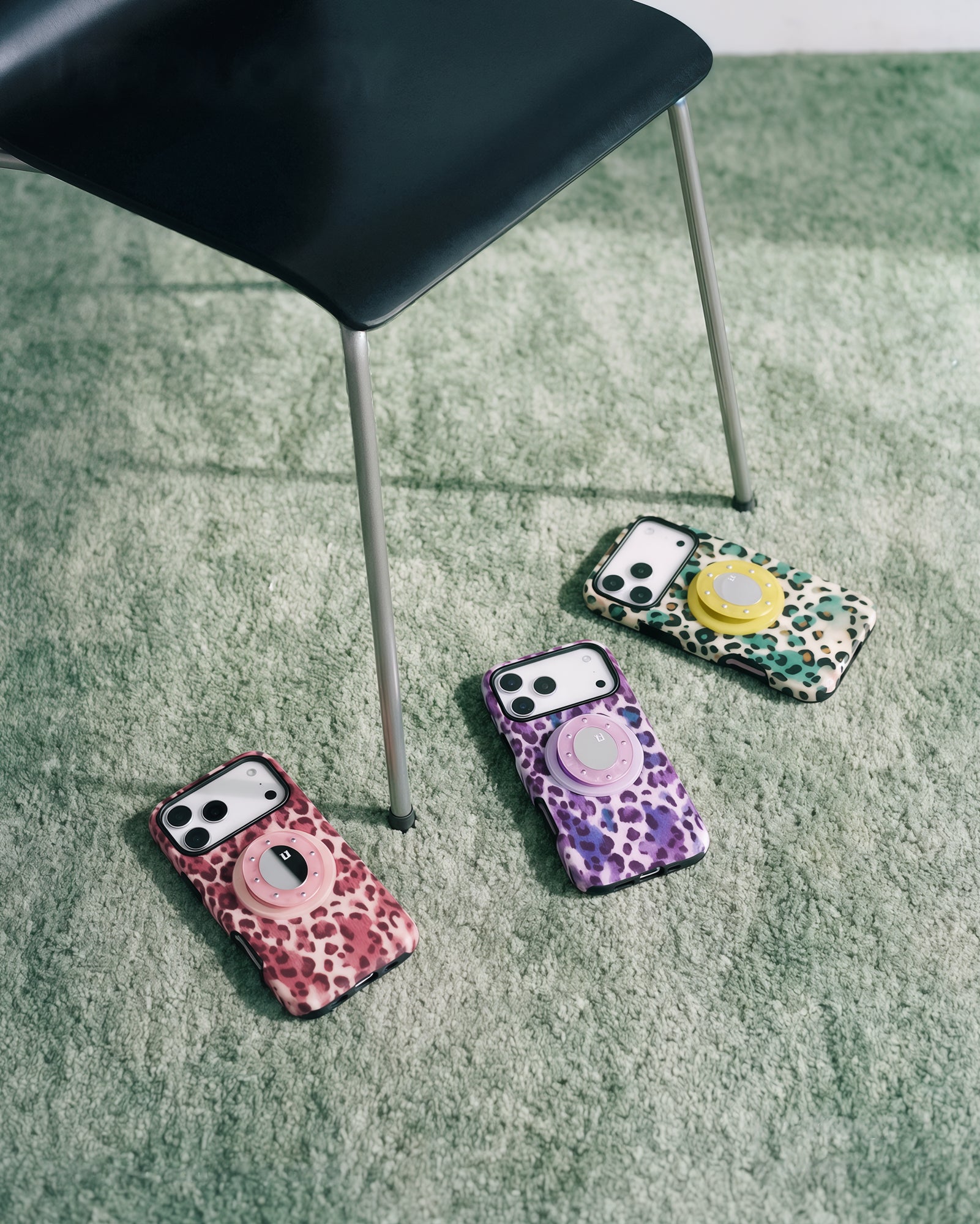 Three STICKYZOO leopard grip cases in violet, pink and green laid out together to show the colorway range