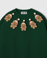Detail of individual gingerbread plush character on forest green STICKYZOO sweatshirt showing texture