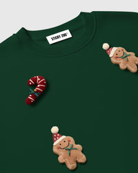 Detail of hand-stitched gingerbread man and candy cane plush on STICKYZOO forest green heavyweight fleece