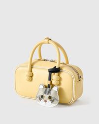 Silver Tabby American Shorthair on a soft-yellow box bag, side angle — Real French leather, 3 days by hand.