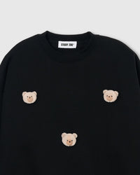 Close-up of plush teddy bear face with gingham-check ears and embroidered features on black cotton