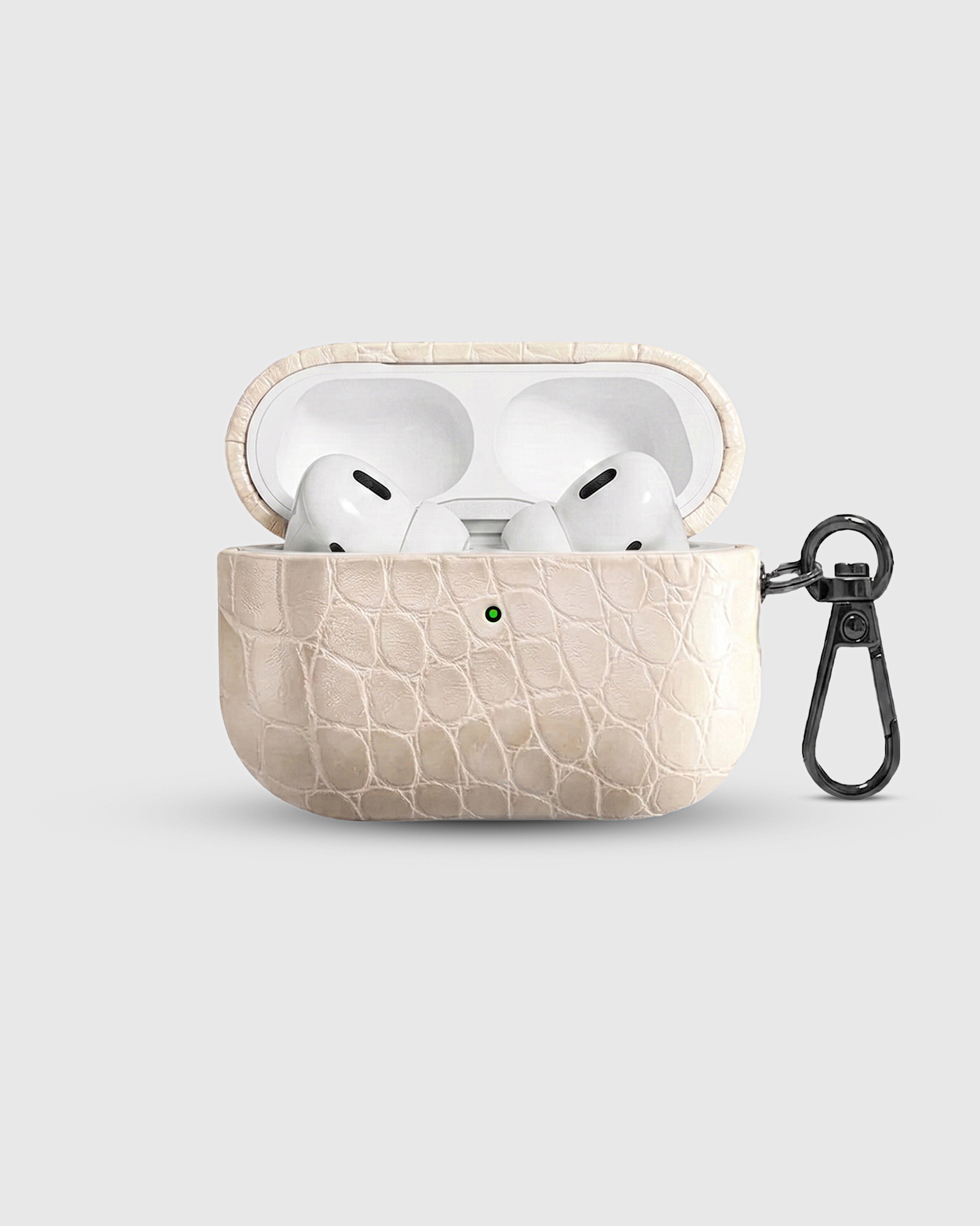 {{AirPods Pro fit securely.}} Ivory Croc case open with AirPods Pro seated inside, croc-embossed lid visible