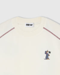 Close-up of embroidered dachshund motif on cream cotton showing stitched detail and bloom back graphic