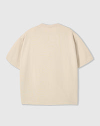 Side view of oversized Hug-Me Bear tee in cream showing dropped shoulders