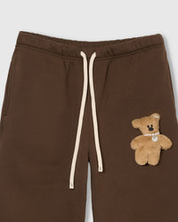 Detail of hand-stitched teddy bear applique on STICKYZOO brown sweatpant showing dimensional craft
