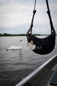 Handmade leather swan bag charm on a handbag by a lakeside — built to last from French Alran goatskin, full-grain leather, 3-day artisan process. STICKYZOO designed in Amsterdam.