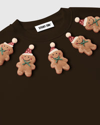 Detail of individual gingerbread plush applique on dark brown STICKYZOO sweatshirt showing 3D depth