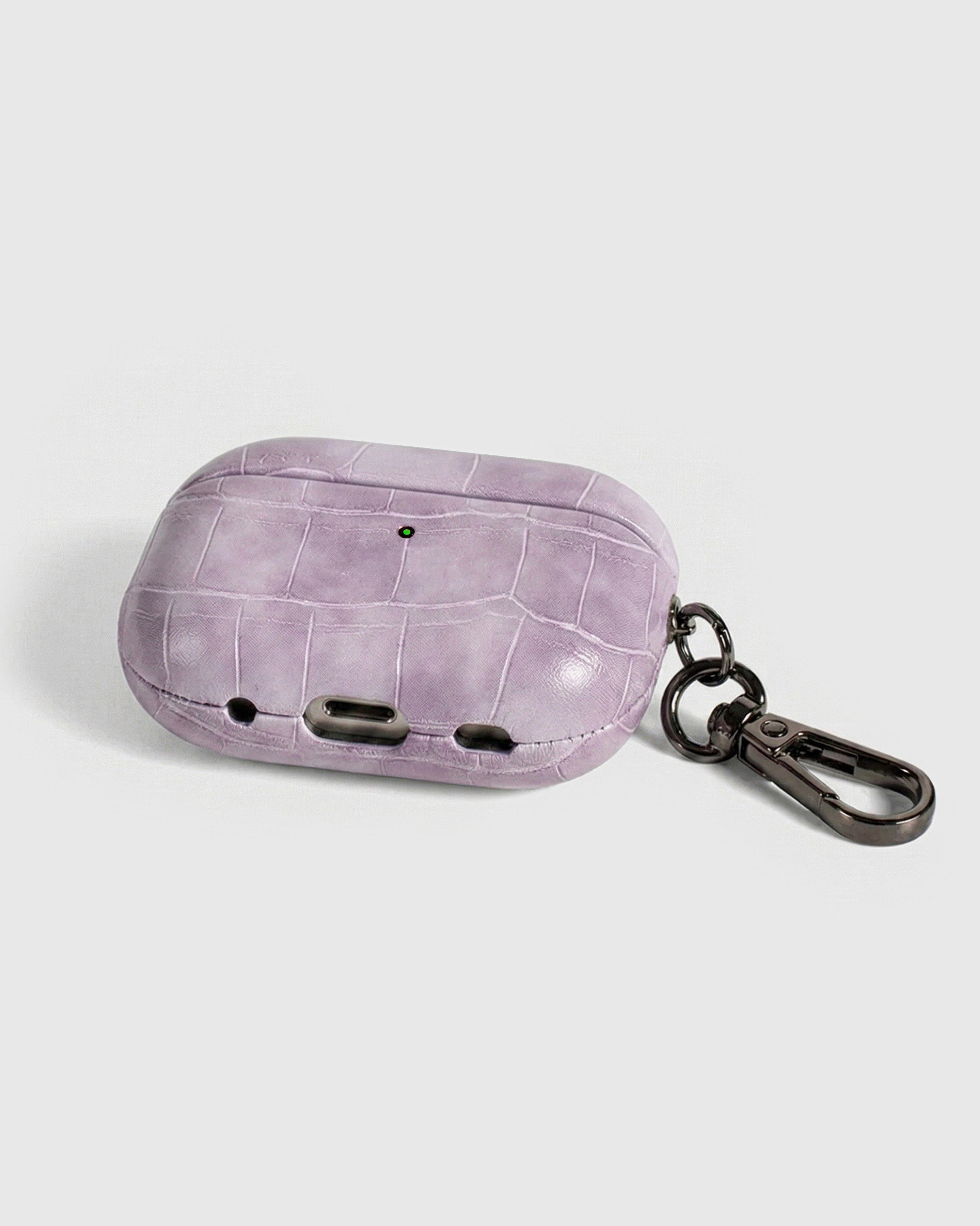 Back view of lavender croc case showing USB-C port, speaker cutouts, and metal carabiner