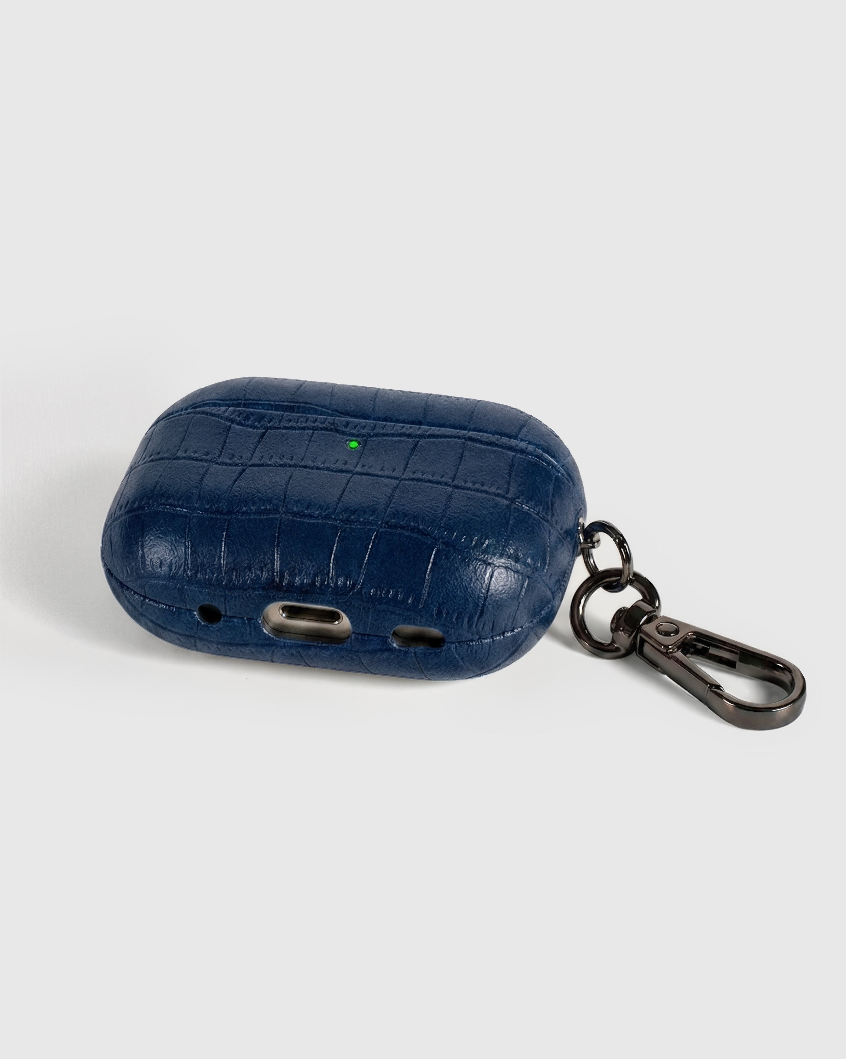 Back view of deep navy vintage croc case showing USB-C port, speaker cutouts, and metal carabiner