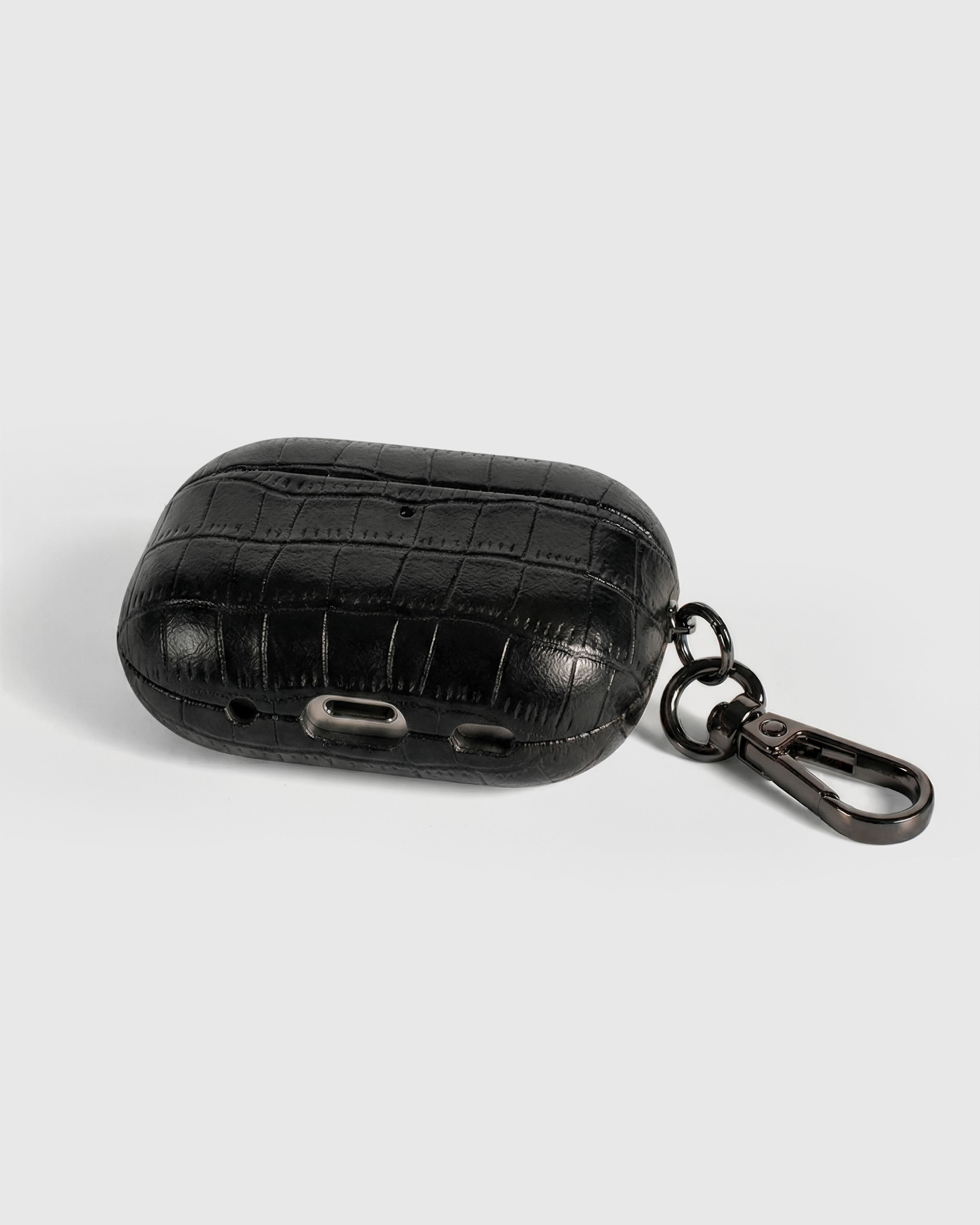Back view of black vintage croc case showing USB-C port, speaker cutouts, and metal carabiner