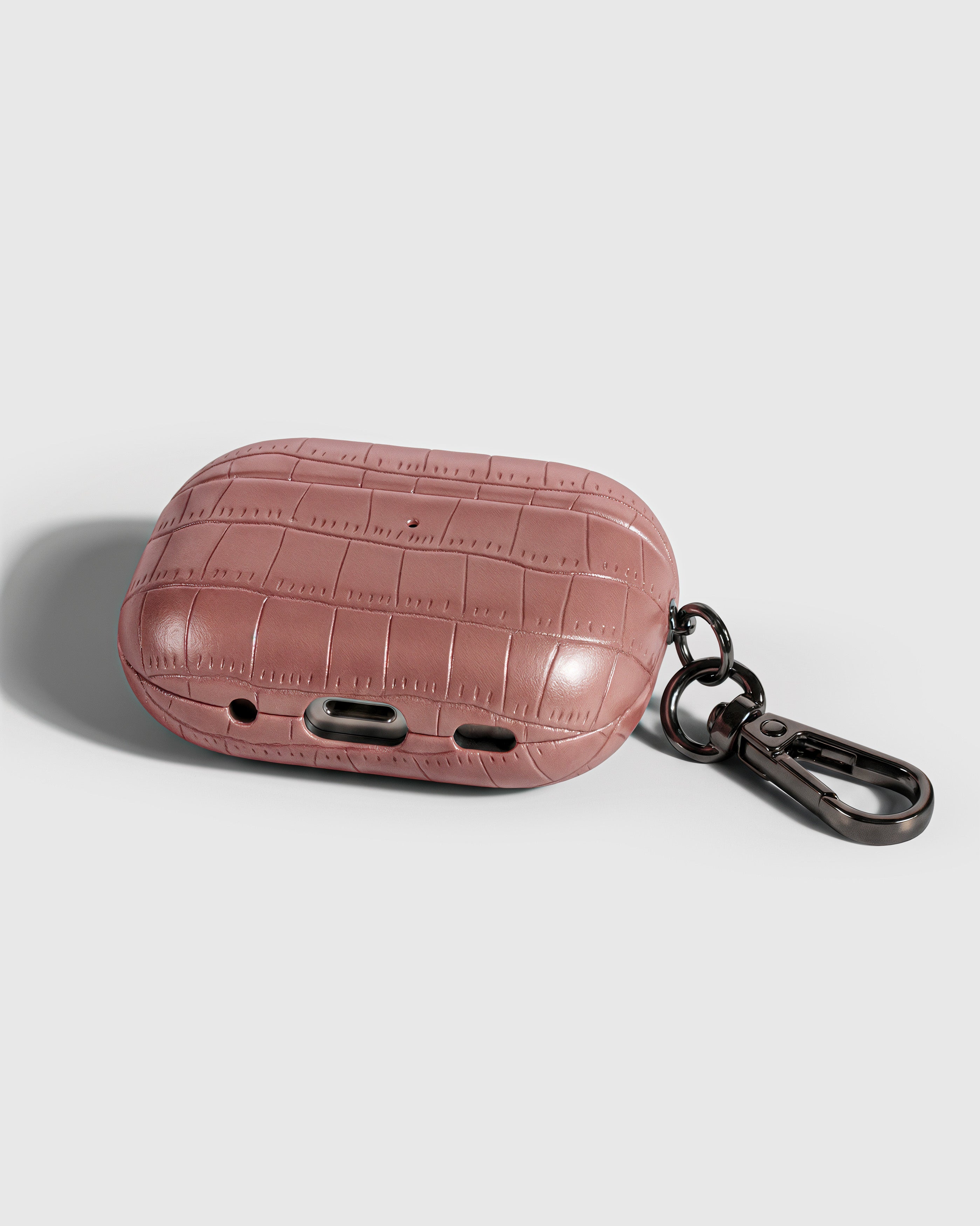 Back view of rose vintage croc case showing USB-C port, speaker cutouts, and metal carabiner