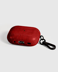 Back view of scarlet vintage croc case showing USB-C port, speaker cutouts, and metal carabiner