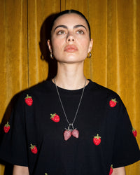 On-model close-up of STICKYZOO Strawberry T-Shirt in black with beaded strawberry necklace