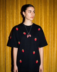 Model wearing STICKYZOO Strawberry T-Shirt in black showing dropped shoulders and plush strawberry scatter